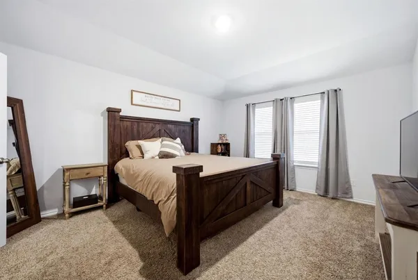 a bedroom with a bed a couch and a large window