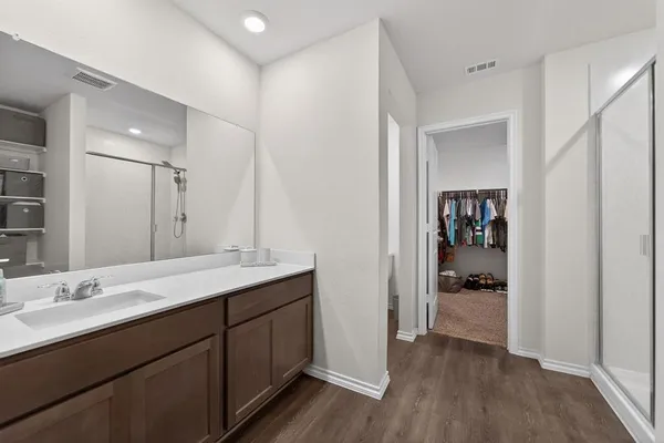 a bathroom with a sink shower and a mirror