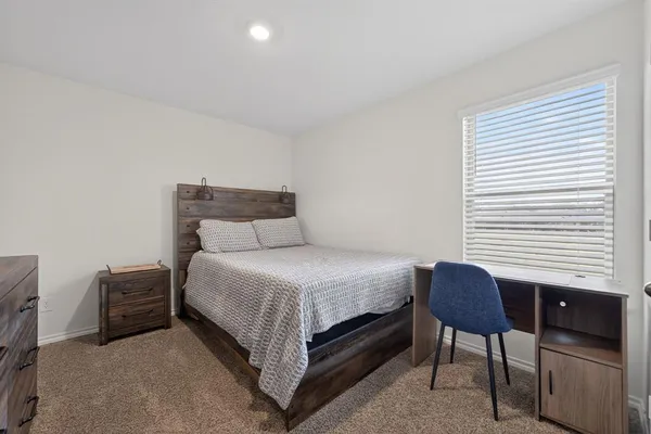 a bedroom with a bed chair and a window