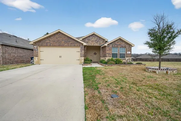 a view of a house with a yard and large tree