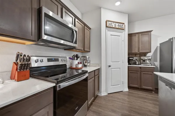a kitchen with stainless steel appliances granite countertop a stove microwave and refrigerator