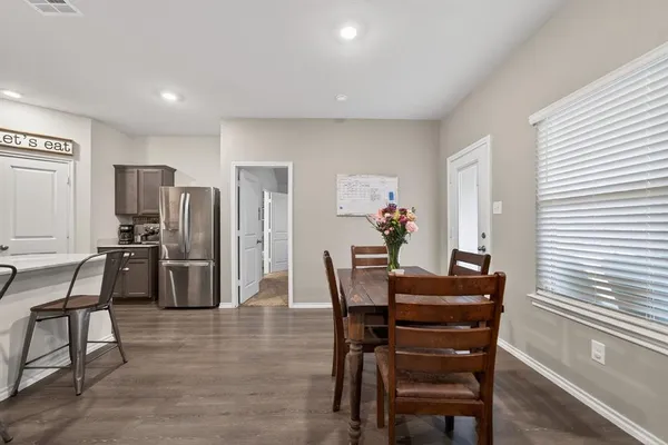 a dining room with furniture and stainless steel appliances