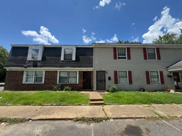 a front view of a house with a yard and a garage