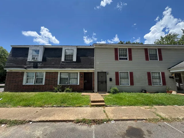 a front view of a house with a yard and a garage