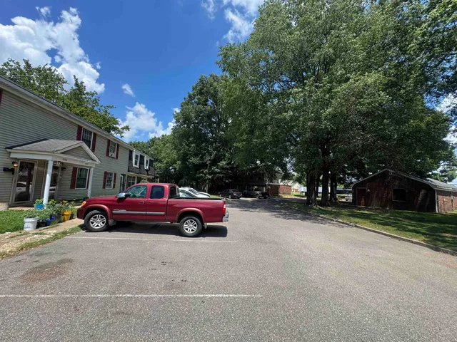 a front view of a house with a garden and parking