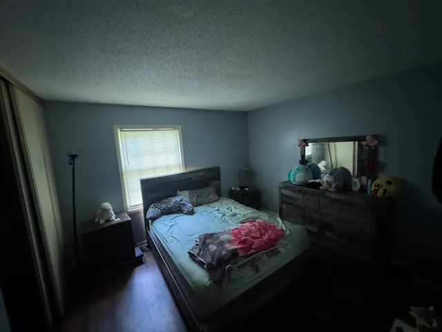 a bedroom with a bed dresser and a window