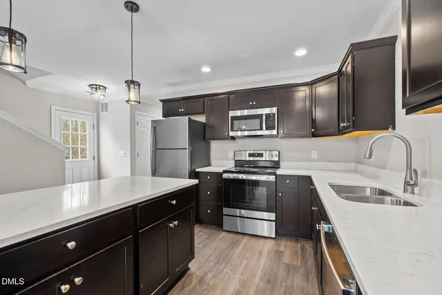 a kitchen with stainless steel appliances a sink stove and refrigerator