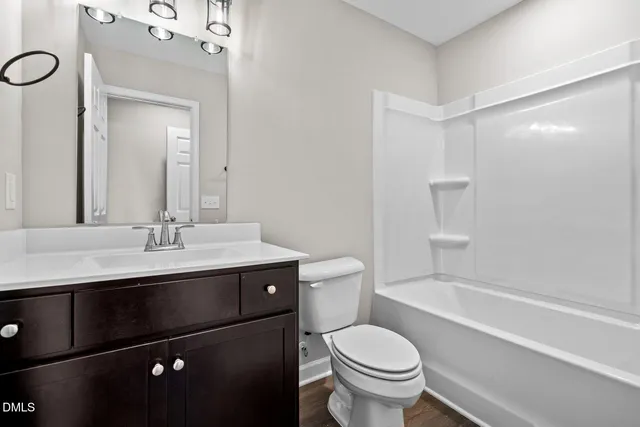 a bathroom with a sink a toilet a mirror and shower