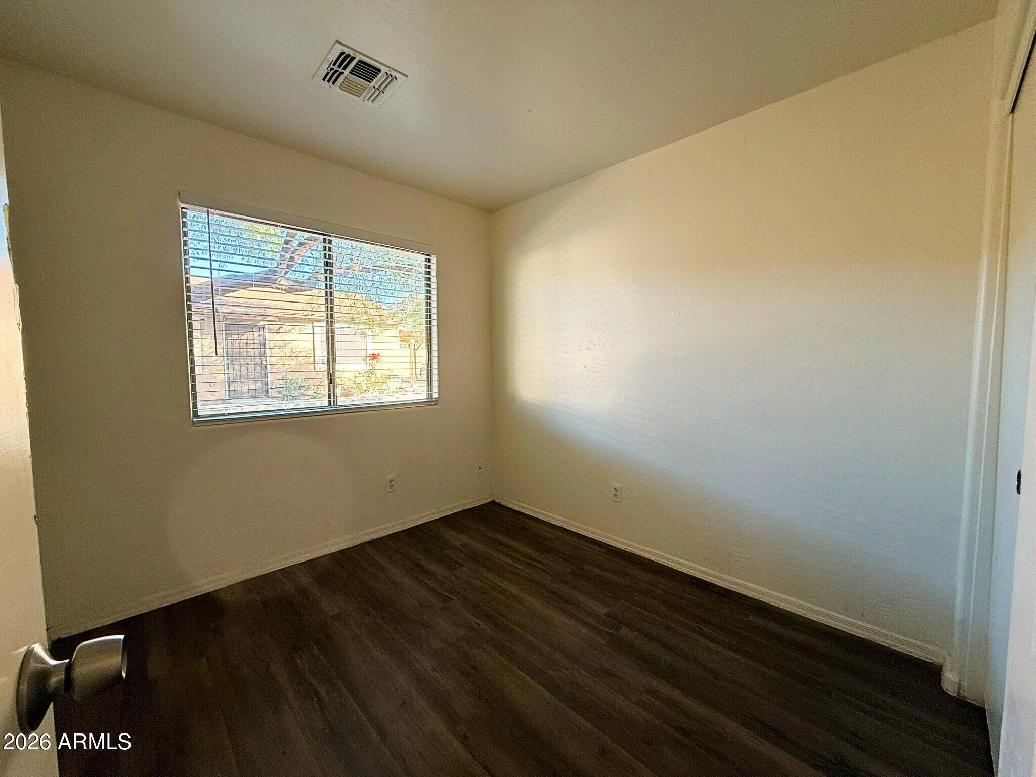 10010 North 7th Avenue, Unit 2 Phoenix, AZ 85021 - Photo 15 of 21 a view of an empty room with wooden floor and a window