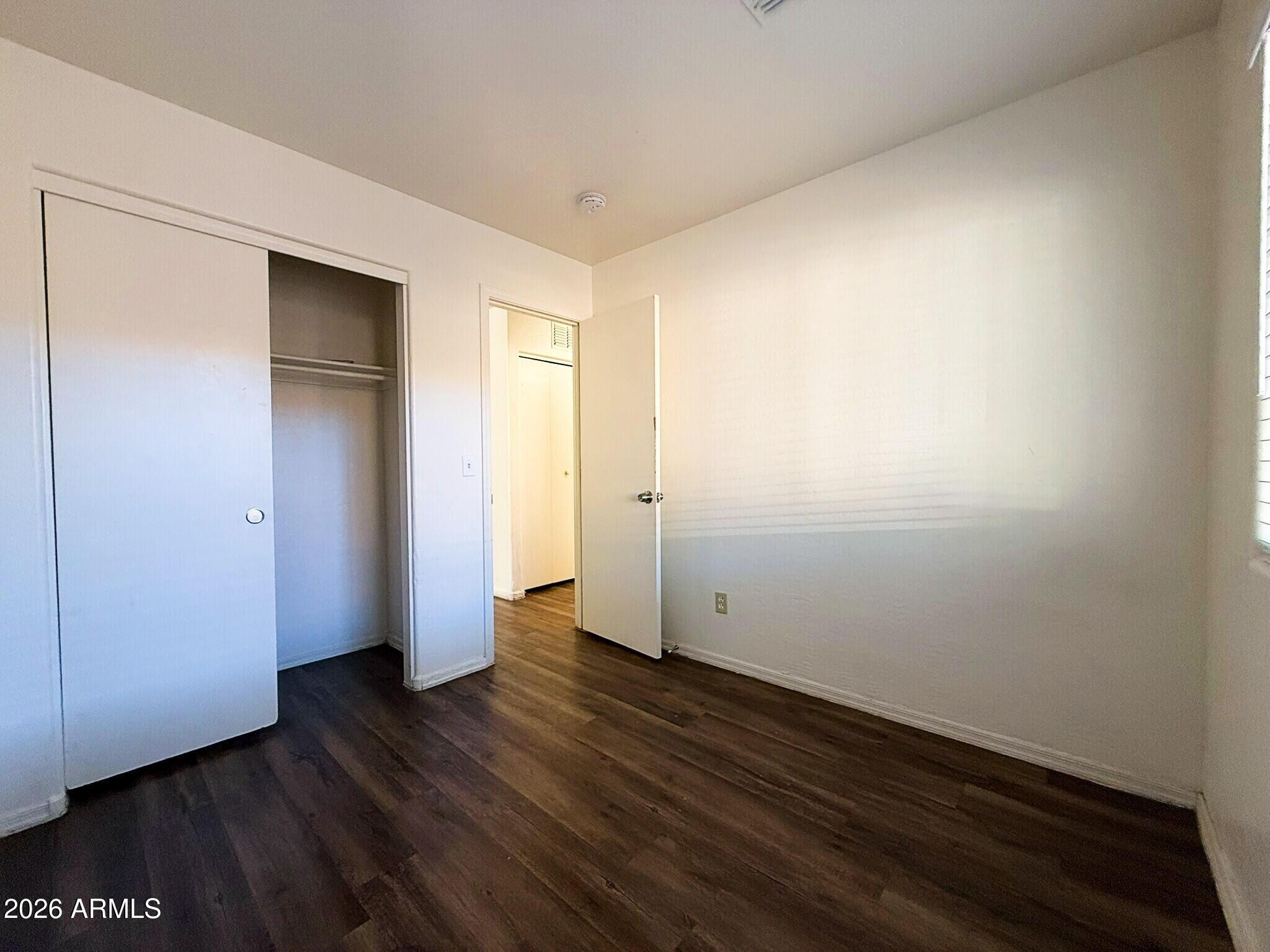 10010 North 7th Avenue, Unit 2 Phoenix, AZ 85021 - Photo 16 of 21 a view of an empty room with wooden floor and closet