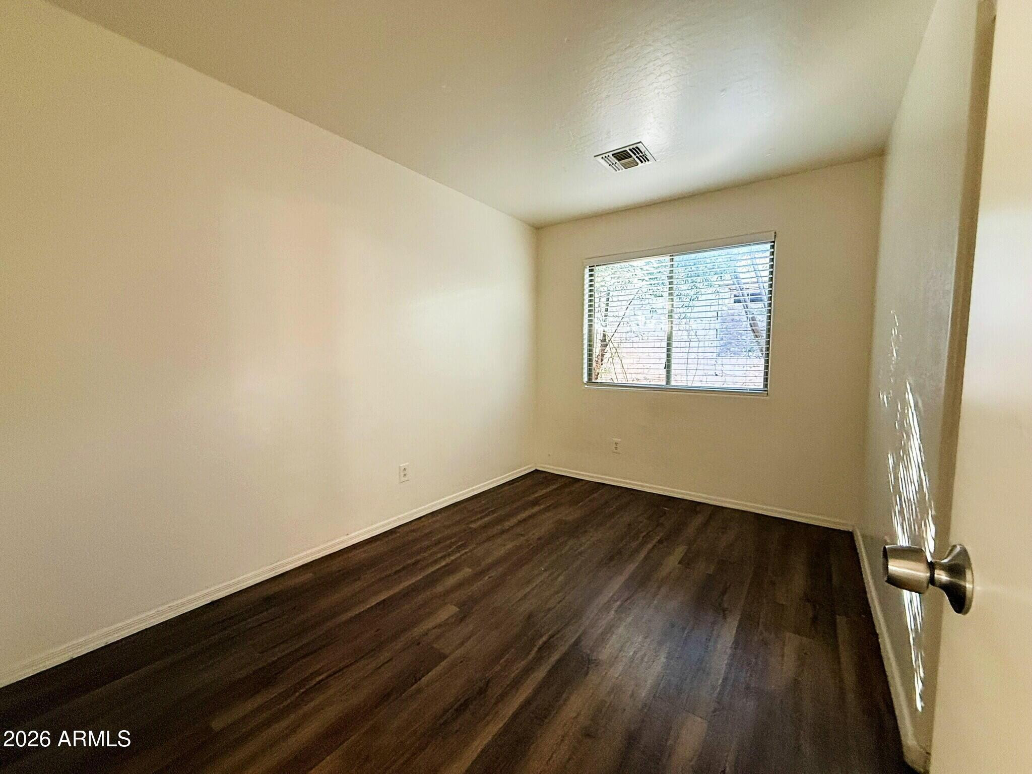 10010 North 7th Avenue, Unit 2 Phoenix, AZ 85021 - Photo 17 of 21 an empty room with wooden floor and windows