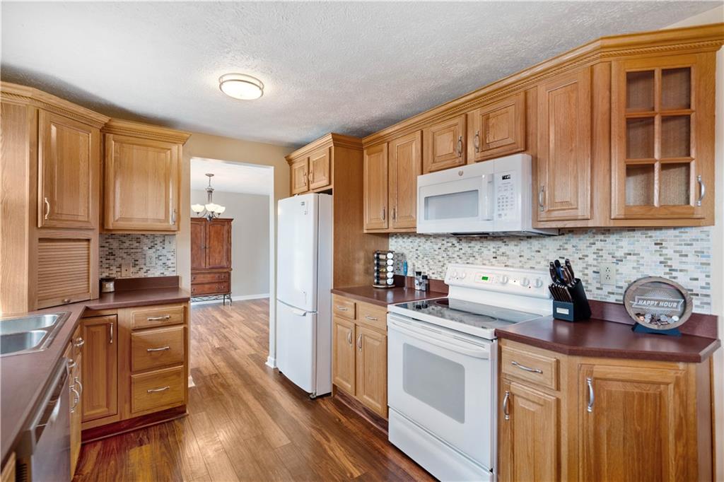 320 Celestial Drive Freedom, PA 15042 - Photo 13 of 28 a kitchen with stainless steel appliances granite countertop a stove a sink dishwasher and a refrigerator with wooden floor