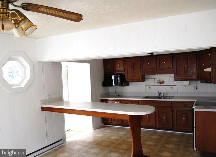 38141 Dukeharts Coltons Point, MD 20626 - Photo 11 of 25 a kitchen with a sink and a wooden cabinets
