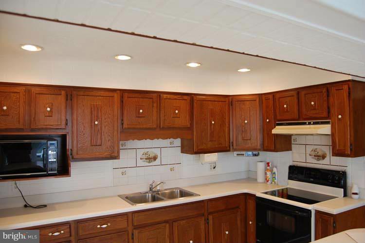 38141 Dukeharts Coltons Point, MD 20626 - Photo 10 of 25 a kitchen with wooden cabinets and a sink