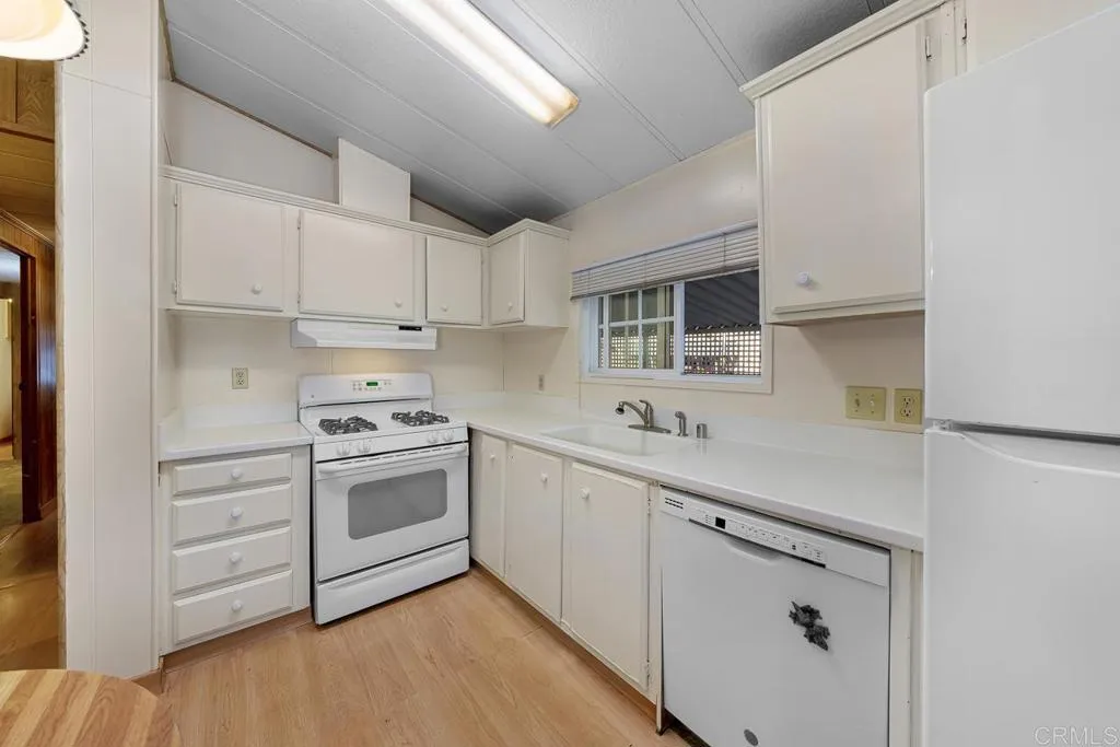 11949 Riverside Drive, Unit 133 Lakeside, CA 92040 - Photo 11 of 32 a kitchen with cabinets stainless steel appliances and sink