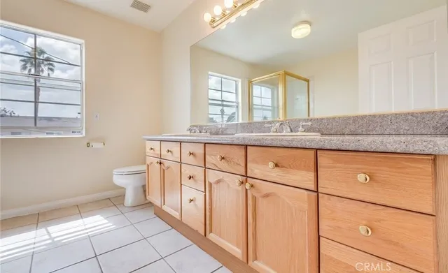 a bathroom with a granite countertop sink mirror vanity and toilet