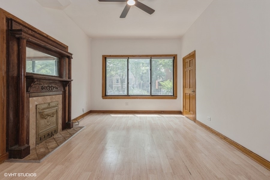 1840 West Huron Street Chicago, IL 60622 - Photo 2 of 11 an empty room with windows fireplace and wooden floor