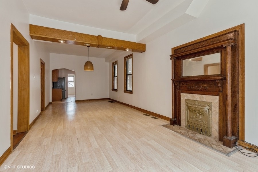 1840 West Huron Street Chicago, IL 60622 - Photo 4 of 11 a view of empty room with wooden floor and fireplace