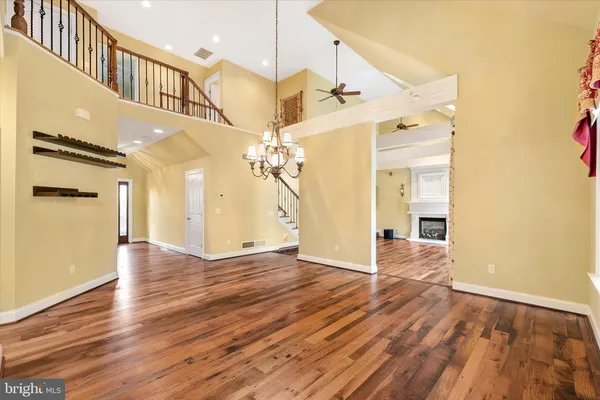 a view of a kitchen island a chandelier and wooden floor