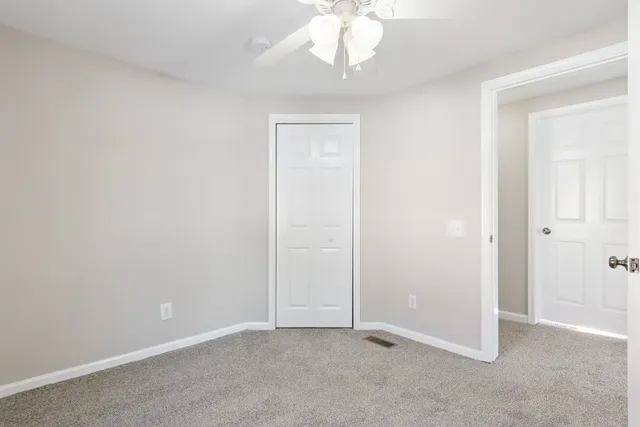 an empty room with a chandelier fan