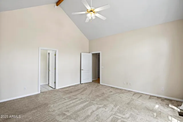 an empty room with closet and a ceiling fan