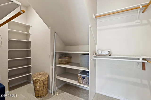 a view of walk in closet with empty racks