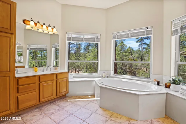a white bath tub sitting in a bathroom next to a window