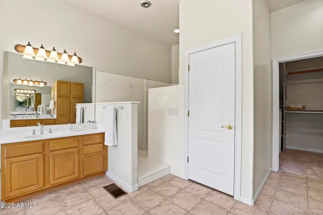 a room with white cabinets and refrigerator