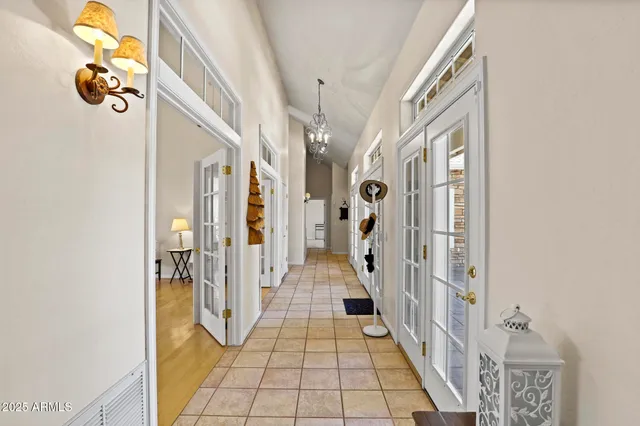 a view of a hallway to a room with windows