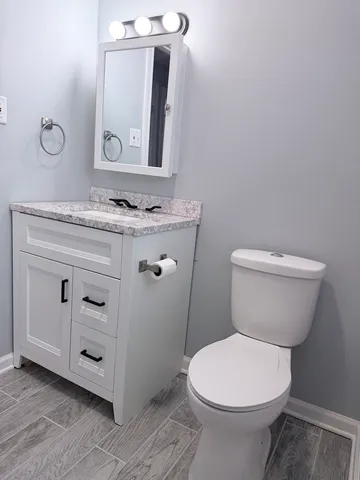 a bathroom with a toilet sink and mirror