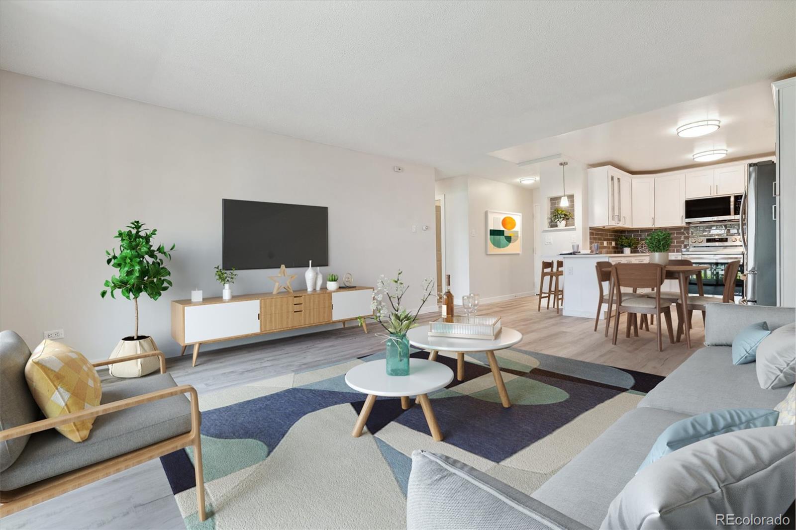 a living room with furniture a flat screen tv and a potted plant