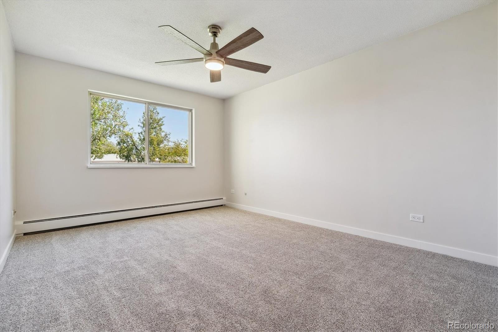 715 South Alton Way, Unit 5A Denver, CO 80247 - Photo 15 of 50 an empty room with windows and a ceiling fan