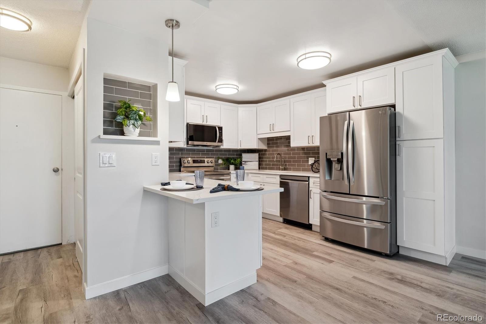 715 South Alton Way, Unit 5A Denver, CO 80247 - Photo 3 of 49 a kitchen with a refrigerator wooden floor and a sink