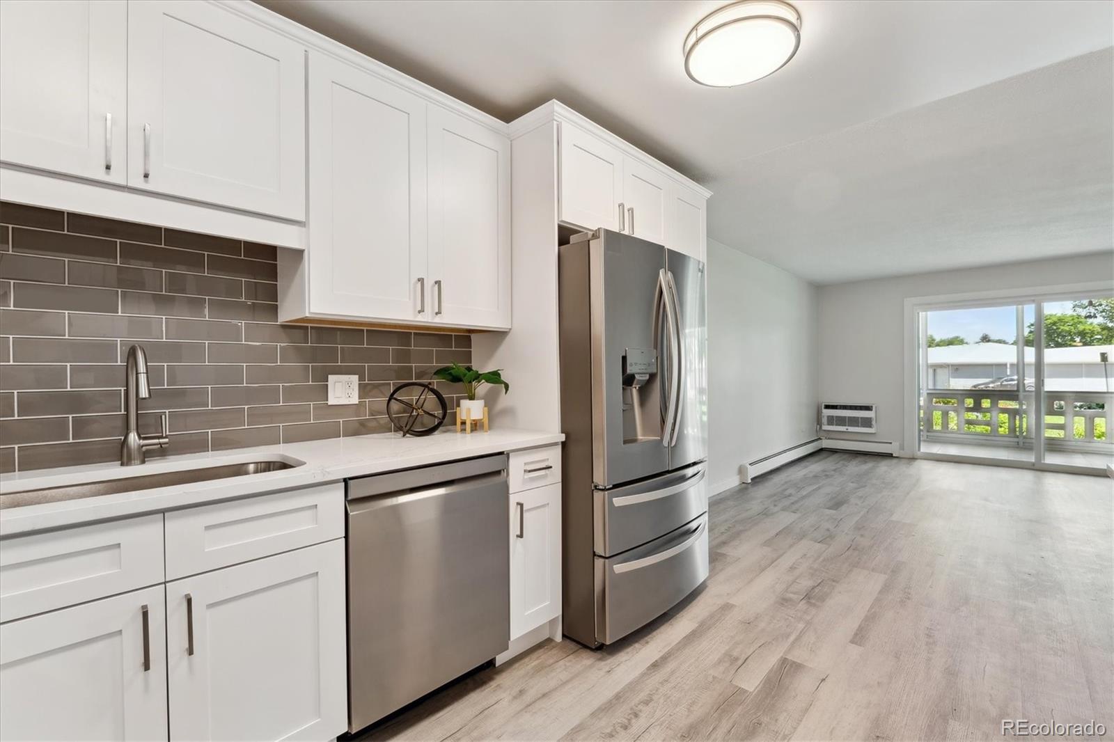 715 South Alton Way, Unit 5A Denver, CO 80247 - Photo 9 of 50 a kitchen with a refrigerator and a sink