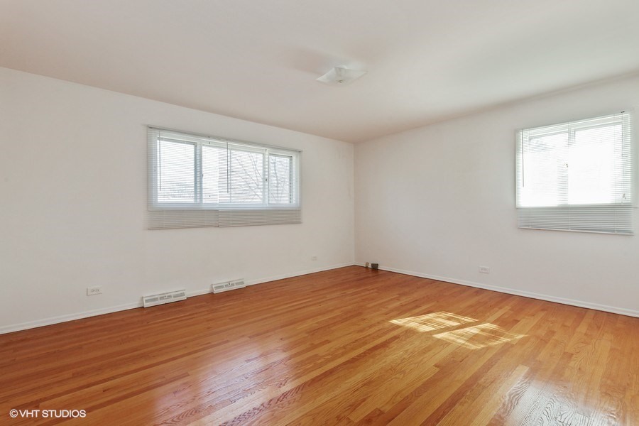 829 Hibbard Road Wilmette, IL 60091 - Photo 9 of 12 a view of an empty room with wooden floor and a window