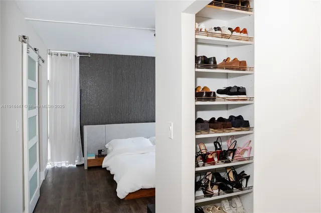 a walk in closet with wooden floor