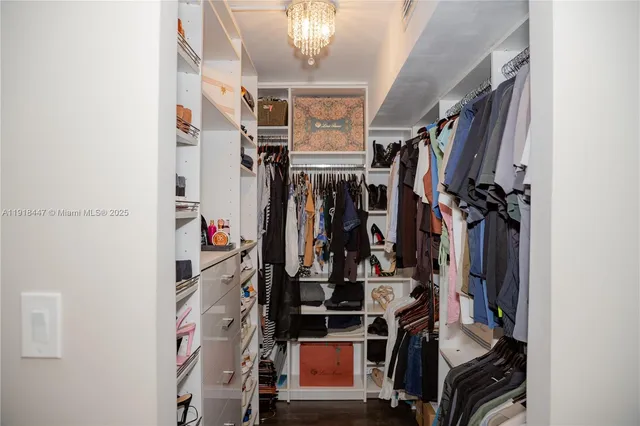 a view of walk in closet with clothes