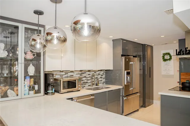 a kitchen with stainless steel appliances granite countertop a sink and a refrigerator