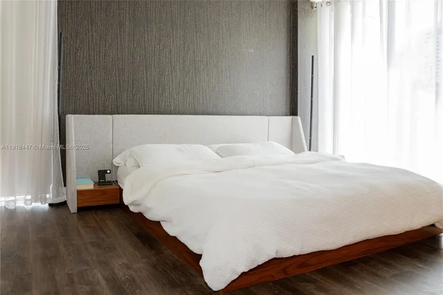 a bed sitting in a bedroom next to a window