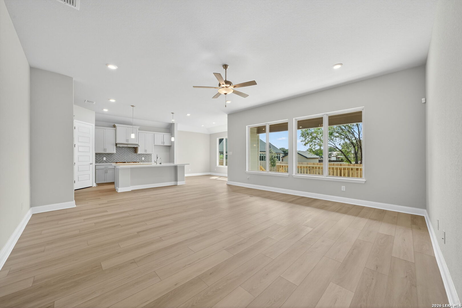 254 Allen Avenue Castroville, TX 78009 - Photo 5 of 24 a view of an empty room with a window and wooden floor