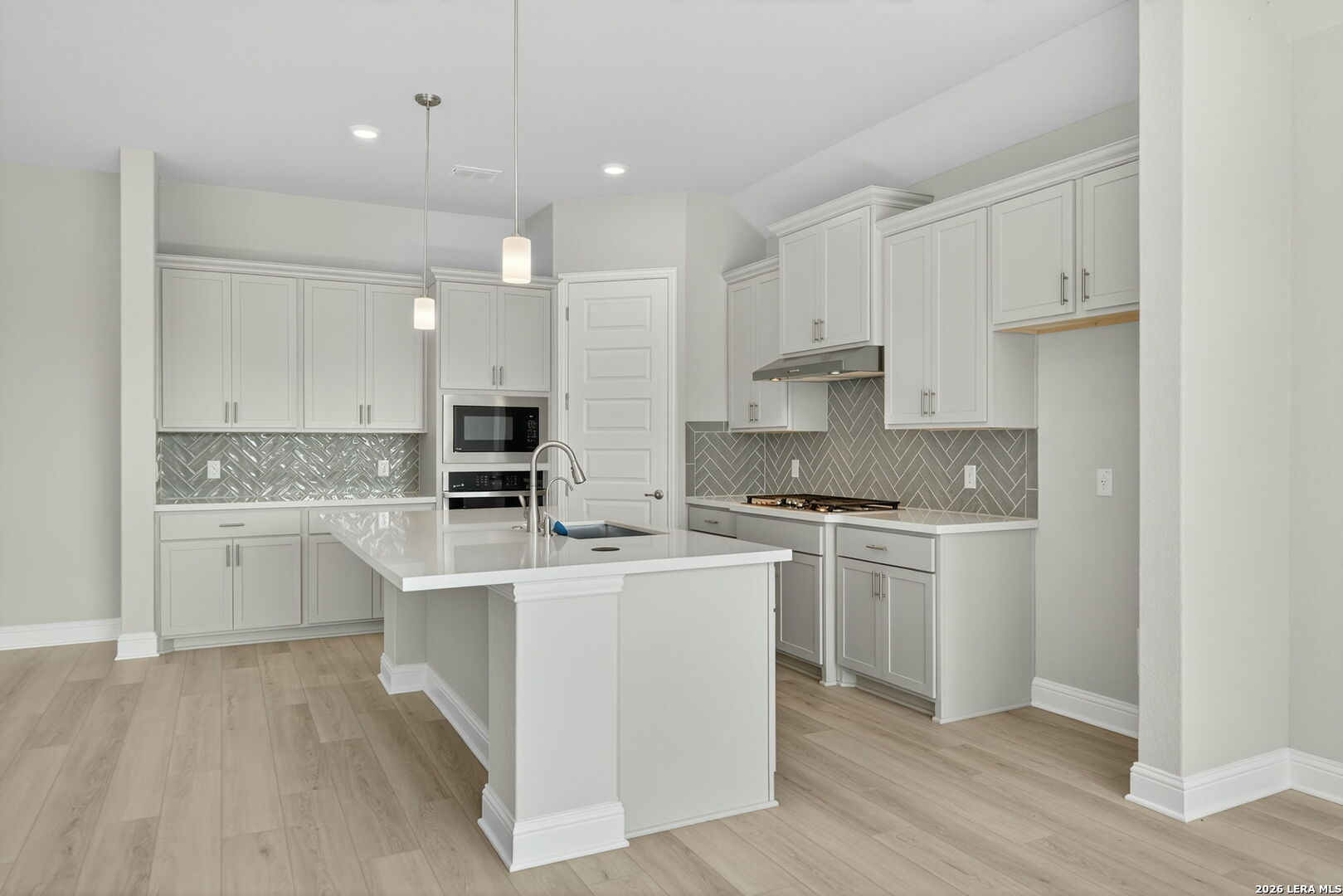 254 Allen Avenue Castroville, TX 78009 - Photo 9 of 24 a kitchen with kitchen island white cabinets and white appliances