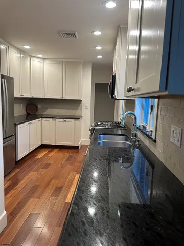 a kitchen with stainless steel appliances a refrigerator sink and wooden cabinets