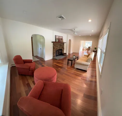 a living room with fireplace furniture and a wooden floor