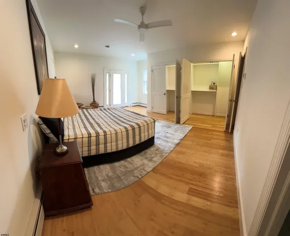 a spacious bedroom with a bed and a mirror