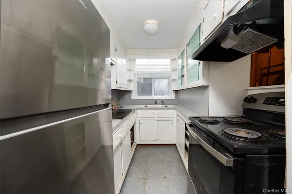 a kitchen with granite countertop a sink a stove and refrigerator