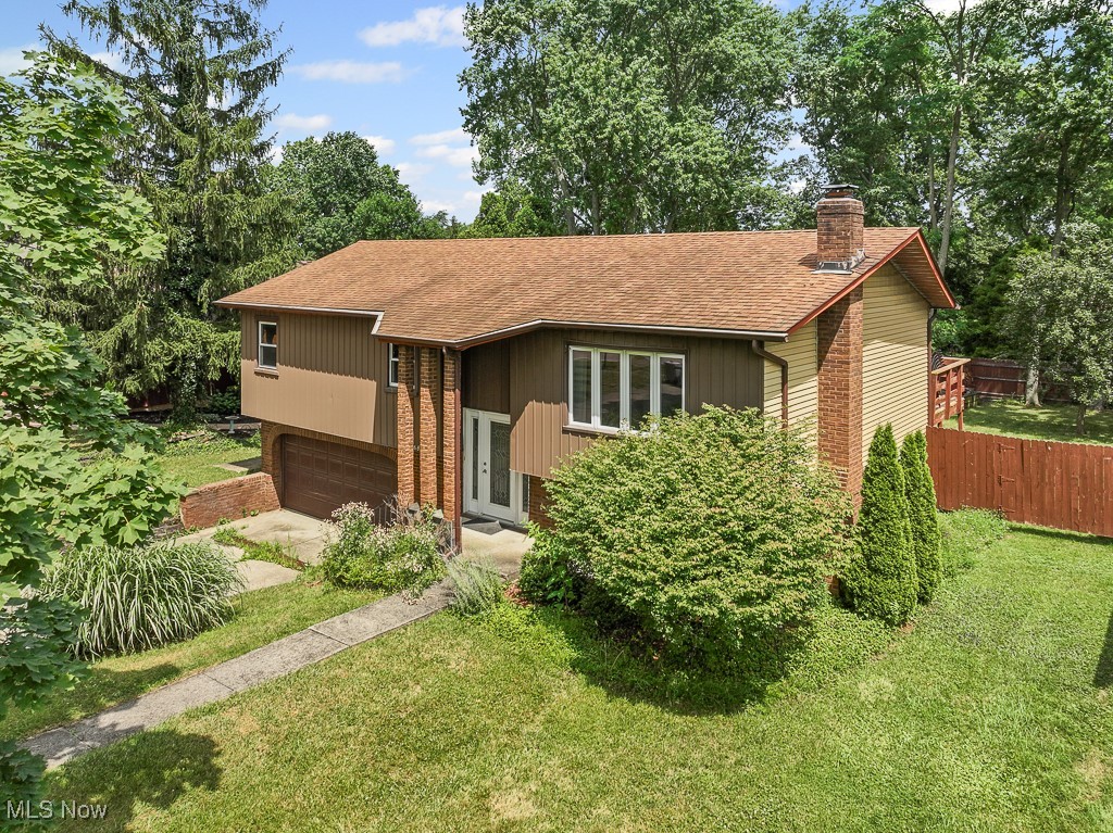 17682 Drake Road Strongsville, OH 44136 - Photo 2 of 45 Raised ranch featuring a chimney, roof with shingles, an attached garage, and driveway