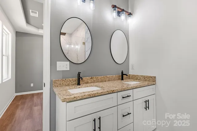 a bathroom with a granite countertop sink and a mirror