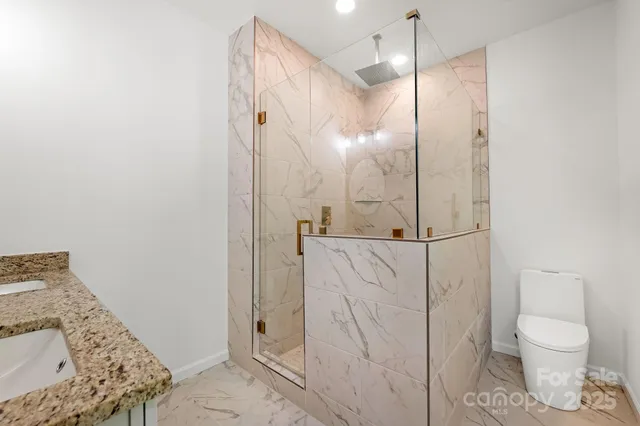 a bathroom with a shower toilet and sink