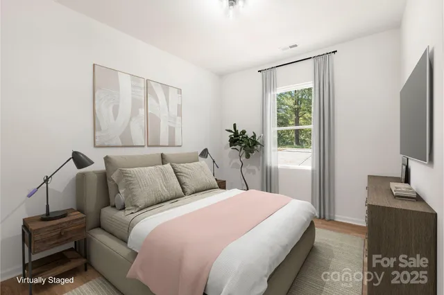 a bedroom with a large bed and a flat tv screen on a dresser