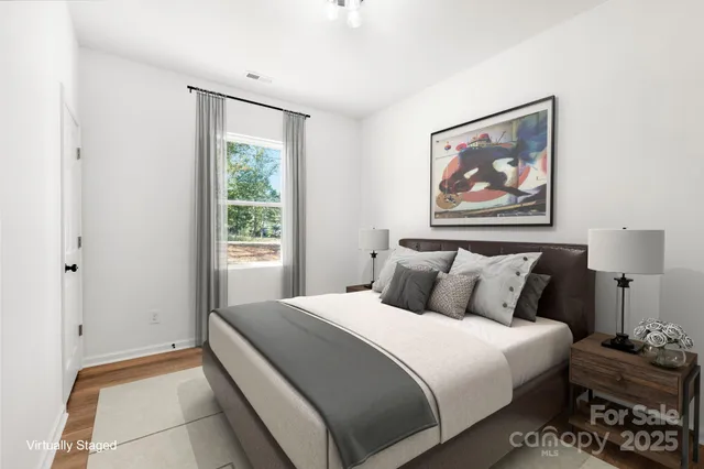 a bedroom with a bed and a painting on the wall